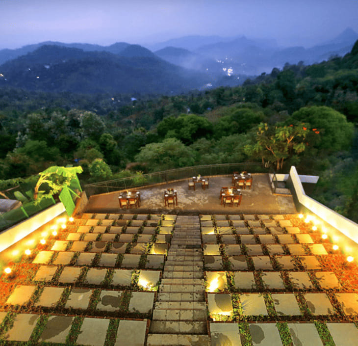 The open terrace laid for dinner at dusk, lights along the steps