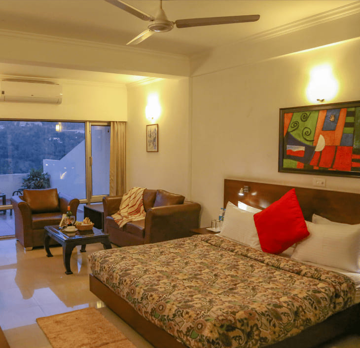 Luxury room with a seating corner and the valley through the glazing